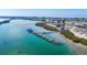 Overhead view showing a marina, waterfront condos, and a pool in a picturesque coastal setting under a clear sky at 6040 Boca Grande Cswy # A2, Boca Grande, FL 33921