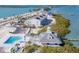 Aerial view of waterfront community featuring pool, marina, and luxurious condominium buildings on a sunny day at 6040 Boca Grande Cswy # A2, Boca Grande, FL 33921