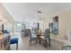 Inviting dining area with a glass table, rattan chairs, and an adjacent modern kitchen at 6040 Boca Grande Cswy # A2, Boca Grande, FL 33921