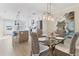Open dining area with rattan chairs, a view into a modern kitchen, and ocean views at 6040 Boca Grande Cswy # A2, Boca Grande, FL 33921