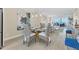 Dining room with views of the living room and ocean, featuring a glass dining table and rattan chairs at 6040 Boca Grande Cswy # A2, Boca Grande, FL 33921