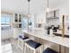 Modern kitchen featuring white cabinets, stainless steel appliances, and a beautiful island with black leather bar stools at 6040 Boca Grande Cswy # A2, Boca Grande, FL 33921