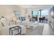 Bright living room with stylish white furnishings and a large sliding glass door to a balcony with ocean views at 6040 Boca Grande Cswy # A2, Boca Grande, FL 33921
