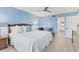A bright main bedroom features light blue walls, hardwood floors, and a glimpse of the bathroom through an open door at 6040 Boca Grande Cswy # A2, Boca Grande, FL 33921