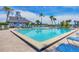Community pool area with crystal clear water, lounge chairs, palm trees and umbrellas, providing a resort-like atmosphere at 6040 Boca Grande Cswy # A2, Boca Grande, FL 33921