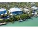 An aerial view showcases the house with dock access, beautifully integrated with the natural surroundings at 62 Tarpon Way, Placida, FL 33946