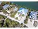 Aerial view of waterfront home with metal roof, lush landscaping, and private dock access at 62 Tarpon Way, Placida, FL 33946