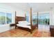 Primary bedroom boasts a beautiful water view, tile floors, and a king-size bed at 62 Tarpon Way, Placida, FL 33946
