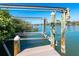 Dock featuring a boat lift and view of the channel, offering direct access to the water at 62 Tarpon Way, Placida, FL 33946