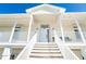 Inviting entrance featuring a stairway leading to a bright white door with sidelights and covered porches at 62 Tarpon Way, Placida, FL 33946