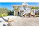 Beautiful two-story home with white exterior, tropical plants, and decorative dolphin statue in the front yard at 62 Tarpon Way, Placida, FL 33946