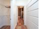 Hallway with storage and a walk-in closet leads to an ensuite bathroom with terracotta tile flooring at 62 Tarpon Way, Placida, FL 33946