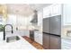 Bright kitchen with stainless steel refrigerator and fixtures, white cabinetry and granite countertops at 62 Tarpon Way, Placida, FL 33946