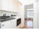 Laundry room with modern washer and dryer, and bright lighting leads into a sunroom at 62 Tarpon Way, Placida, FL 33946