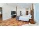 Spacious main bedroom features a four-poster bed, terracotta tile flooring, and an entertainment center at 62 Tarpon Way, Placida, FL 33946