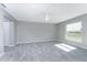 Spacious bedroom with wood-look tile, ceiling fan, and natural light from the window at 6602 David Blvd, Port Charlotte, FL 33981