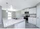 Open kitchen featuring a large island with granite countertops, stainless appliances, and ample lighting at 6602 David Blvd, Port Charlotte, FL 33981
