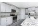Well-equipped kitchen with stainless steel appliances, white cabinets, granite countertops, and center island at 6602 David Blvd, Port Charlotte, FL 33981