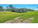 Backyard view with overgrown grass; rear of home shows wear; needs some TLC at 698 & West W Perry St, Englewood, FL 34223