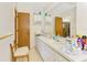 Well-lit bathroom featuring a double sink vanity, storage cabinets, and a full mirror at 698 & West W Perry St, Englewood, FL 34223