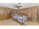 Cozy bedroom with wood paneled walls, a ceiling fan, and comfortable furnishings at 698 & West W Perry St, Englewood, FL 34223