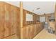 Hallway with wood paneling, carpet flooring, storage shelves, and a window with blinds at 698 & West W Perry St, Englewood, FL 34223