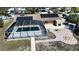 Aerial view of screened pool, patio, solar panels, and colorful exterior home design at 741 W Perry St, Englewood, FL 34223