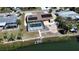 Aerial view showcasing a screened pool, dock, and waterfront access, complete with tropical landscaping at 741 W Perry St, Englewood, FL 34223