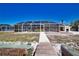 View from the dock of the screen enclosed pool and colorful exterior at 741 W Perry St, Englewood, FL 34223