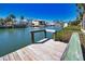 Wooden dock extends into a canal with homes across the way and palm trees, providing waterfront access and scenic views at 741 W Perry St, Englewood, FL 34223