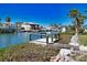 Waterfront property with a private dock, canal, and lush tropical landscaping under a clear blue sky at 741 W Perry St, Englewood, FL 34223