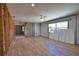 Spacious living room featuring wood-look flooring, ceiling fan, and natural light from the windows at 741 W Perry St, Englewood, FL 34223