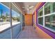 Screened-in porch with tiled floor, ceiling fan, and colorful house exterior at 741 W Perry St, Englewood, FL 34223