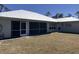 Well manicured backyard features a lush lawn, a metal roof, and a lovely screened-in porch at 7499 Clearwater St, Englewood, FL 34224