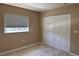 Bedroom features a large closet, a window with pleated shades and neutral carpet at 7499 Clearwater St, Englewood, FL 34224