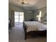 Serene main bedroom with a ceiling fan, lanai access, and an en-suite bathroom at 7499 Clearwater St, Englewood, FL 34224