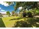Lush backyard featuring green grass, mature trees, and a white fence at 820 Bayshore Dr, Englewood, FL 34223