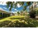 Expansive backyard featuring lush lawn, mature trees, and a white fence providing privacy at 820 Bayshore Dr, Englewood, FL 34223