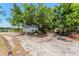 View of a spacious gravel driveway leading to a detached garage, providing ample parking and storage at 820 Bayshore Dr, Englewood, FL 34223