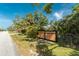 Street view of fenced gate surrounded by lush tropical landscaping offering privacy at 820 Bayshore Dr, Englewood, FL 34223