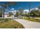 Property with a long drive leading to a beautiful home, featuring a white gate and manicured lawn at 820 Bayshore Dr, Englewood, FL 34223