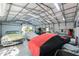 Large garage featuring multiple classic cars, open door, and storage shelves, ideal for collectors and hobbyists at 820 Bayshore Dr, Englewood, FL 34223