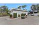 Detached two-car garage next to a golf cart on a gravel drive, surrounded by greenery at 820 Bayshore Dr, Englewood, FL 34223