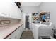 Well-equipped laundry room featuring ample cabinet space and a convenient exterior door at 820 Bayshore Dr, Englewood, FL 34223