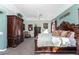 Spacious bedroom featuring a decorative wood bed frame, ceiling fan and light green colored walls at 820 Bayshore Dr, Englewood, FL 34223
