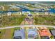 Aerial view showcasing the property with waterfront access, lush landscaping, and an inviting neighborhood at 8251 Arlewood Cir, Port Charlotte, FL 33981