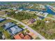 Panoramic aerial view of the neighborhood with boat canals, lush greenery, and various residential homes at 8251 Arlewood Cir, Port Charlotte, FL 33981