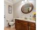 Well-lit bathroom featuring a dark vanity, decorative mirror, and functional layout at 8251 Arlewood Cir, Port Charlotte, FL 33981