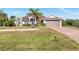 Charming single-story home featuring a manicured lawn and a two-car garage at 8251 Arlewood Cir, Port Charlotte, FL 33981