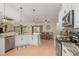 Kitchen with stainless steel appliances, white cabinets and seamless flow to the living room at 8251 Arlewood Cir, Port Charlotte, FL 33981